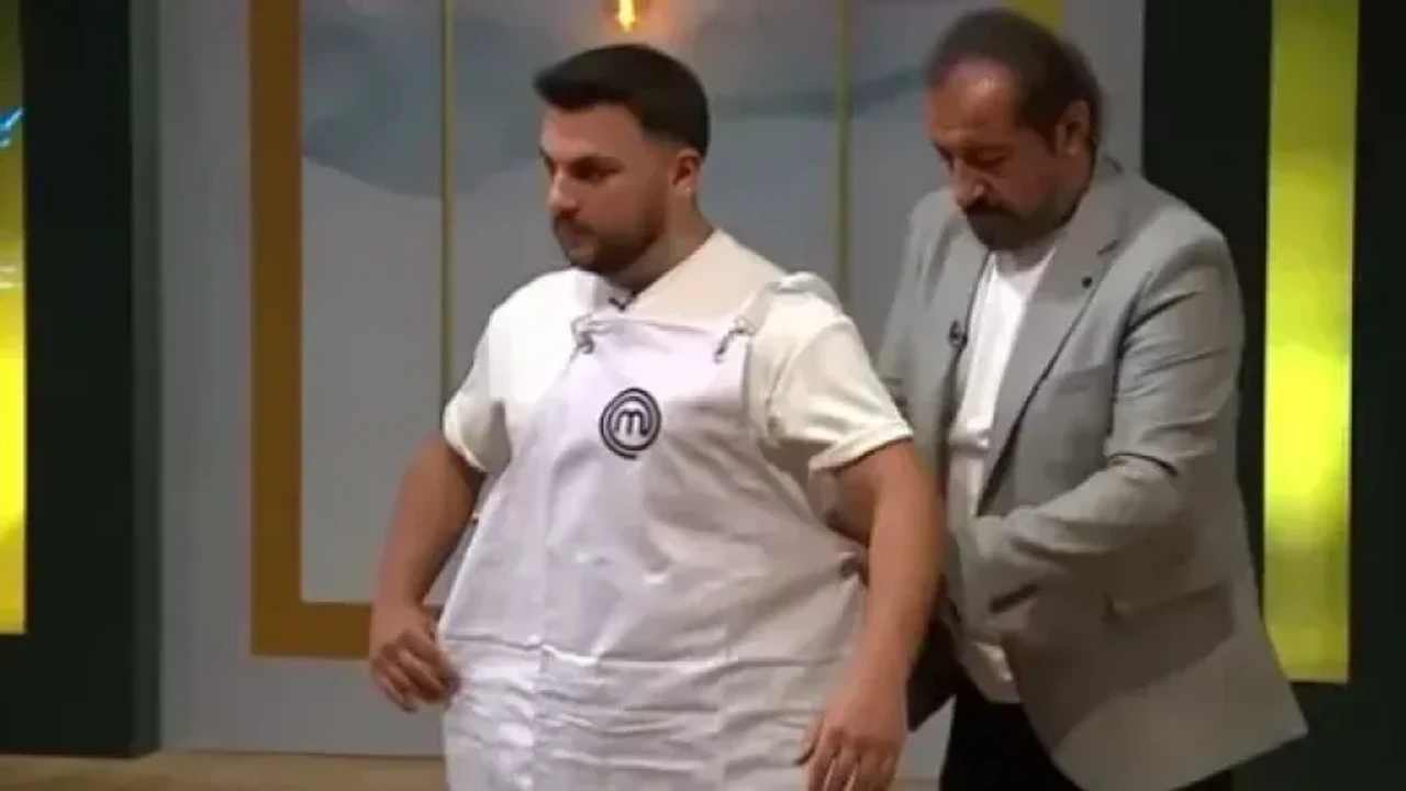 [Resi̇m Furkan Kahraman'ın Masterchef Önlüğüyle Çekilmiş, Kendine Güvenen Bir Poz Verdiği Profesyonel Bir Portre Fotoğrafı